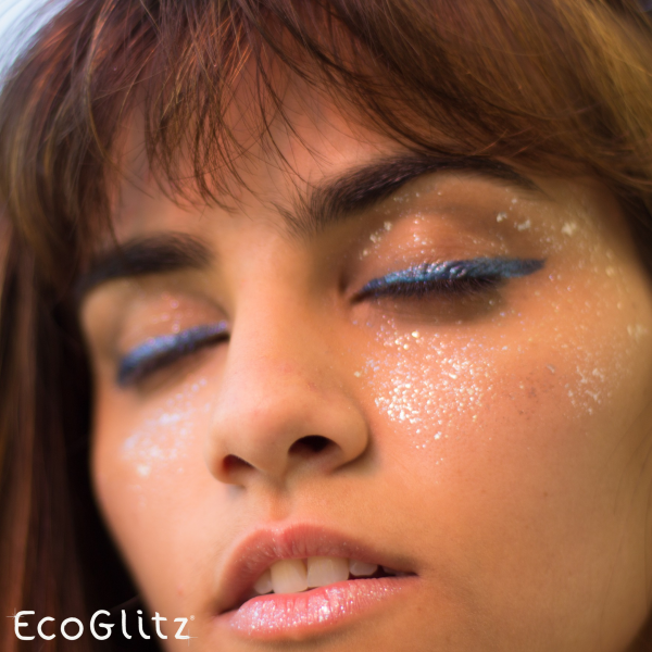 young model wearing blue glitter eyeliner and white sparkles on cheeks